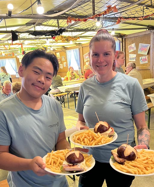 Vereinsmitglieder präsentieren den «Smashiversary»-Burger. Foto: zVg